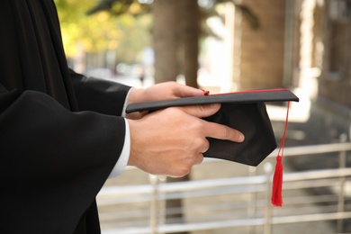 Student with graduation hat outdoors on sunny day, closeup