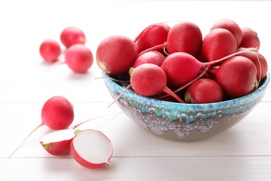 Photo of Bowl with fresh ripe radishes on white wooden table