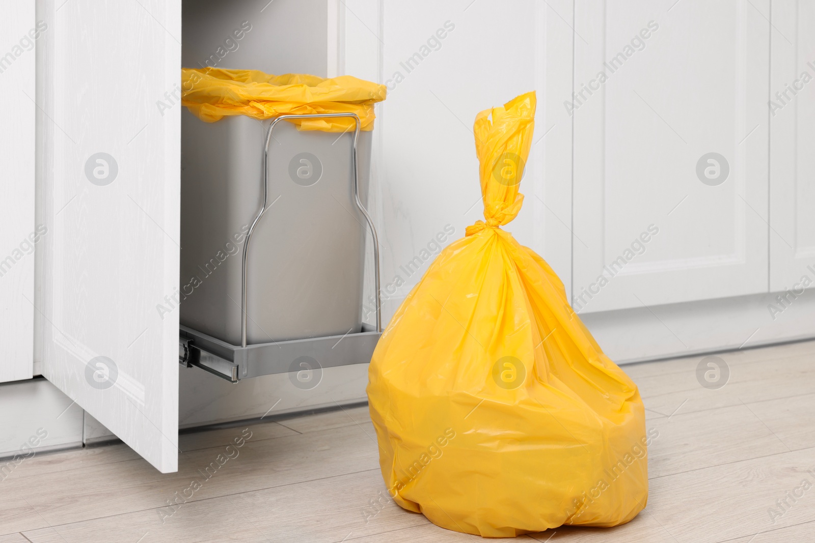 Photo of Plastic garbage bag and trash can indoors