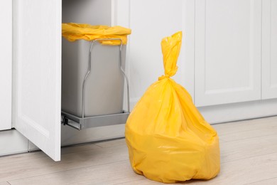 Photo of Plastic garbage bag and trash can indoors