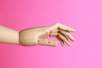 Wooden hand model on pink background. Mannequin part