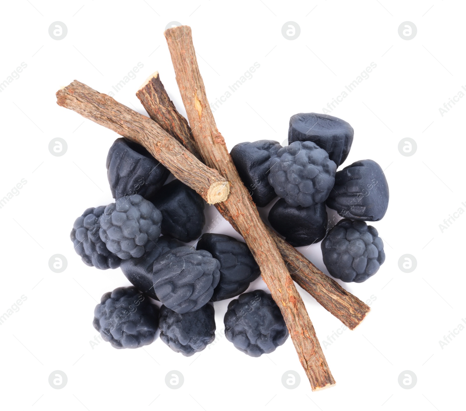 Photo of Many tasty candies and dried sticks of liquorice root isolated on white, top view