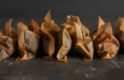 Photo of Many used tea bags on black table, closeup