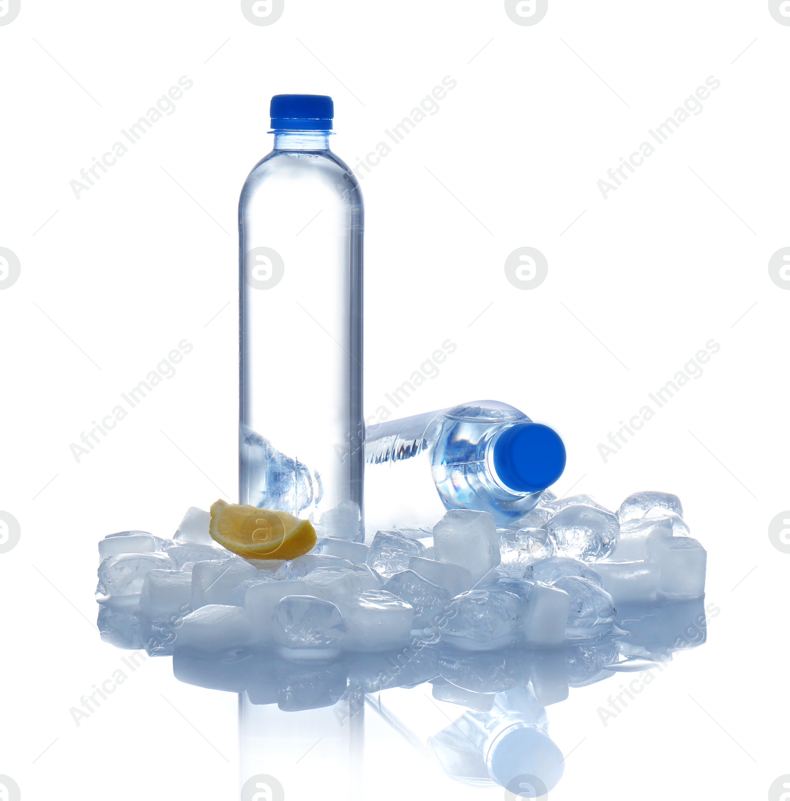 Photo of Bottles of water, lemon slice and ice cubes on white background