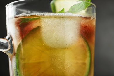 Photo of Cup of refreshing iced tea on grey background, closeup