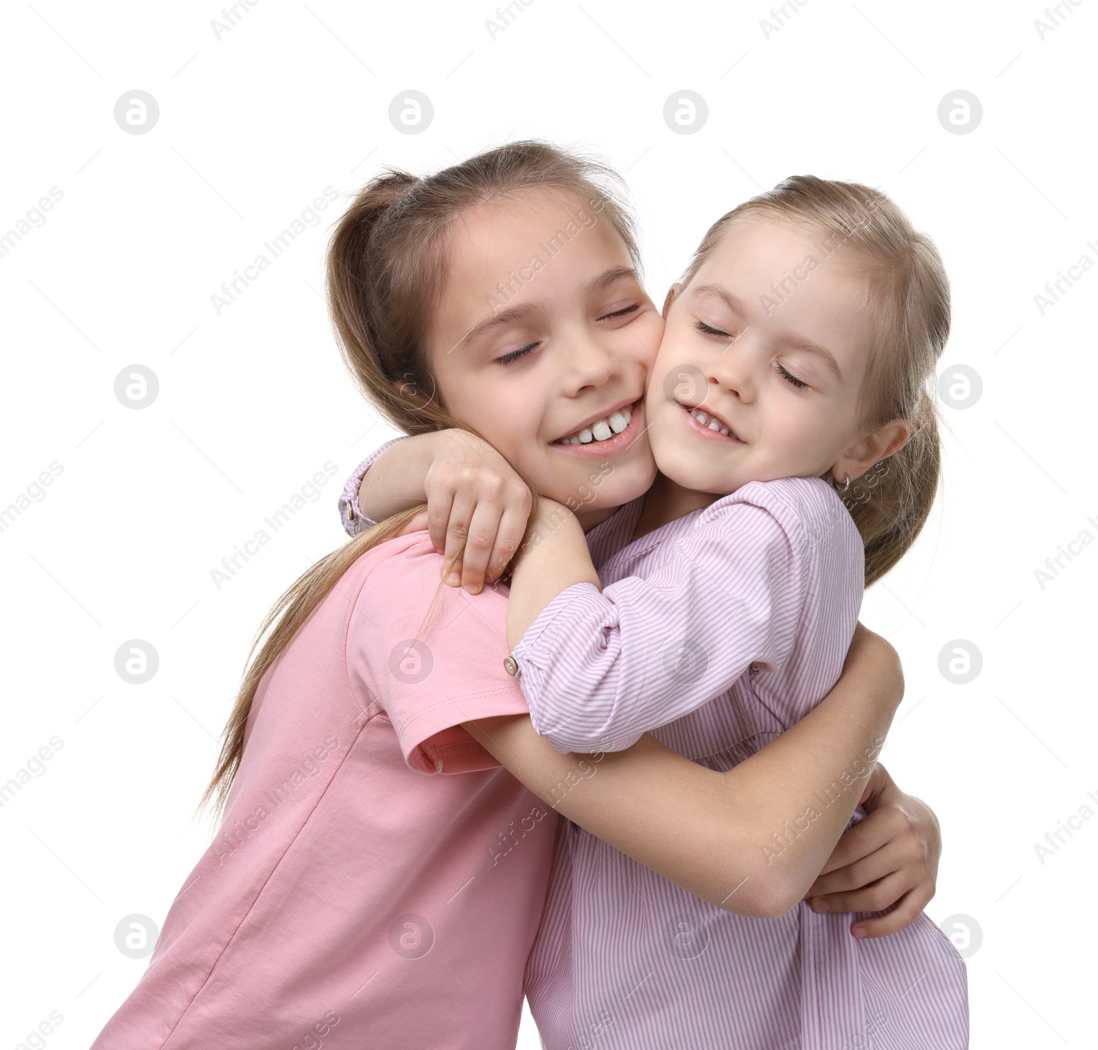 Photo of Portrait of cute little sisters on white background