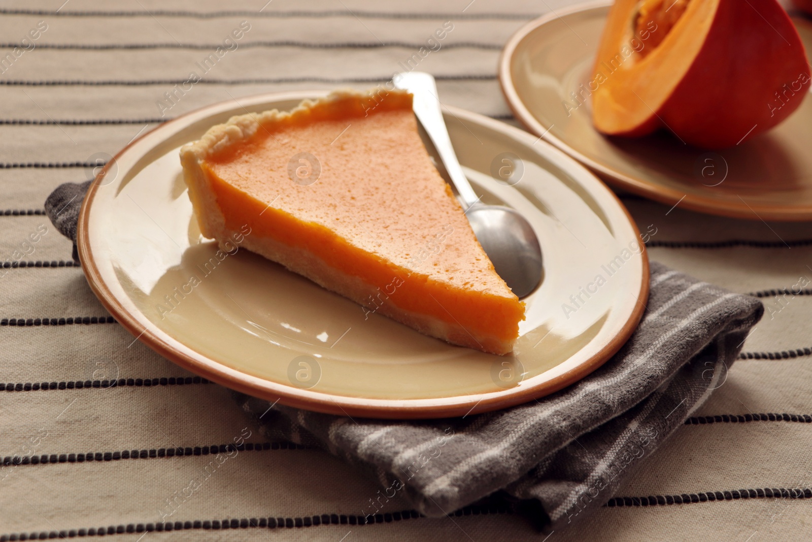 Photo of Plate with piece of fresh homemade pumpkin pie on table