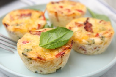 Photo of Freshly baked bacon and egg muffins with cheese on plate, closeup