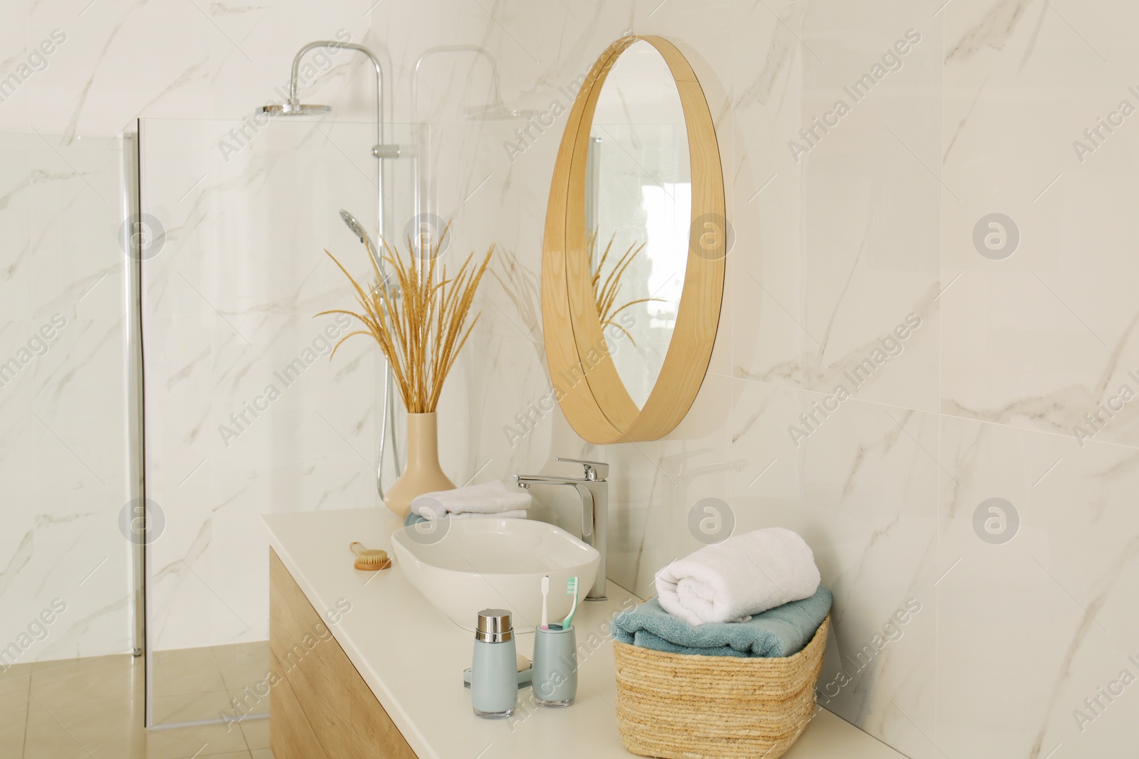 Photo of Round mirror over vessel sink in stylish bathroom interior