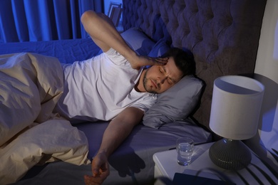 Sleepy handsome man in dark room at night. Bedtime