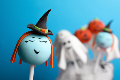 Delicious Halloween themed cake pops on light blue background, closeup. Space for text