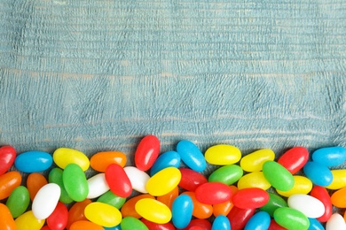 Photo of Flat lay composition with jelly beans on color background. Space for text