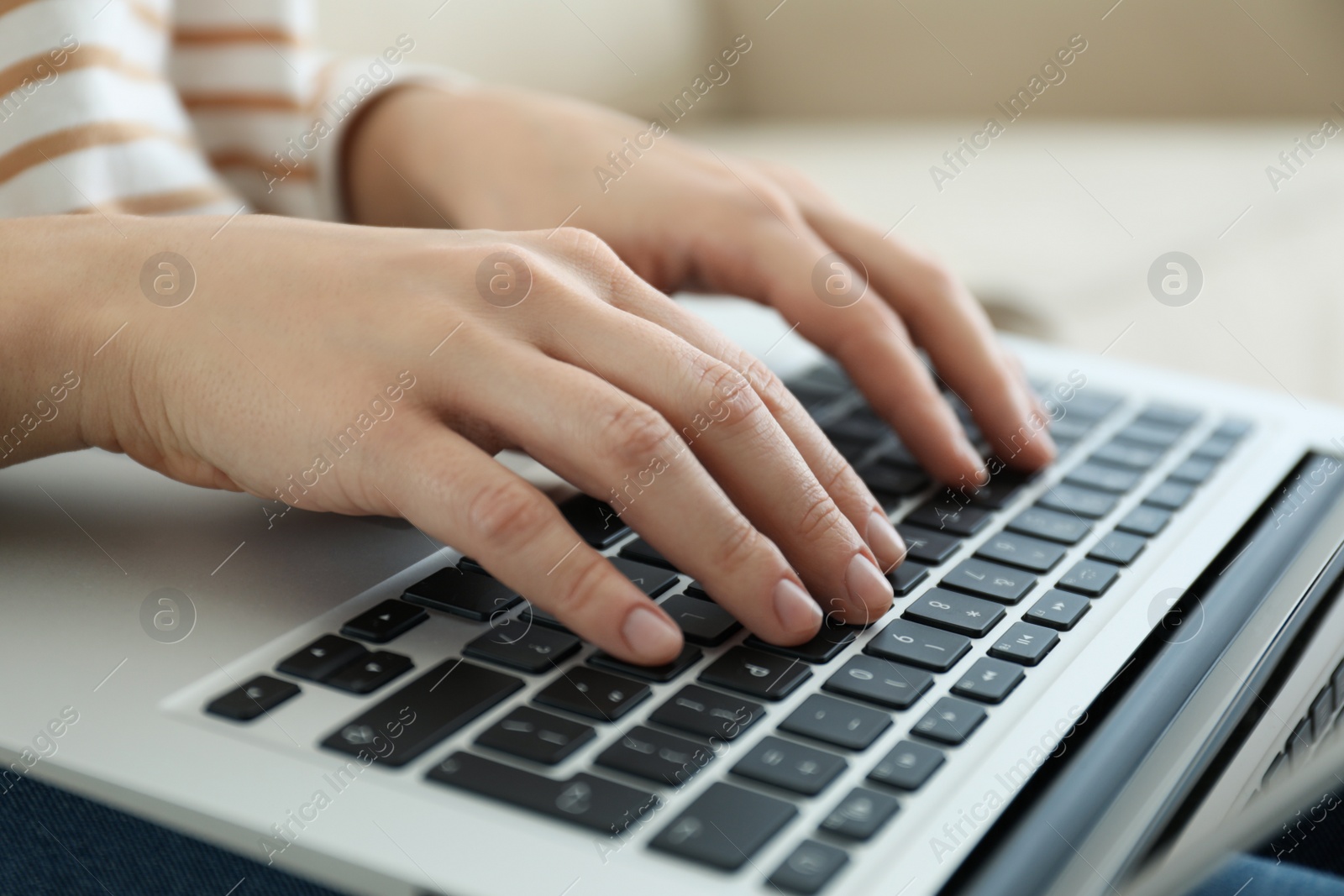 Photo of Woman working on modern laptop at home, closeup