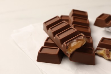 Photo of Tasty chocolate bars on white table, space for text