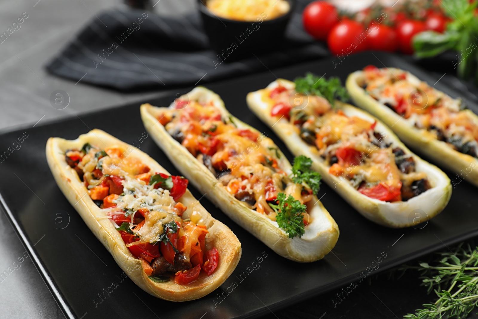 Photo of Delicious stuffed zucchini served on grey table