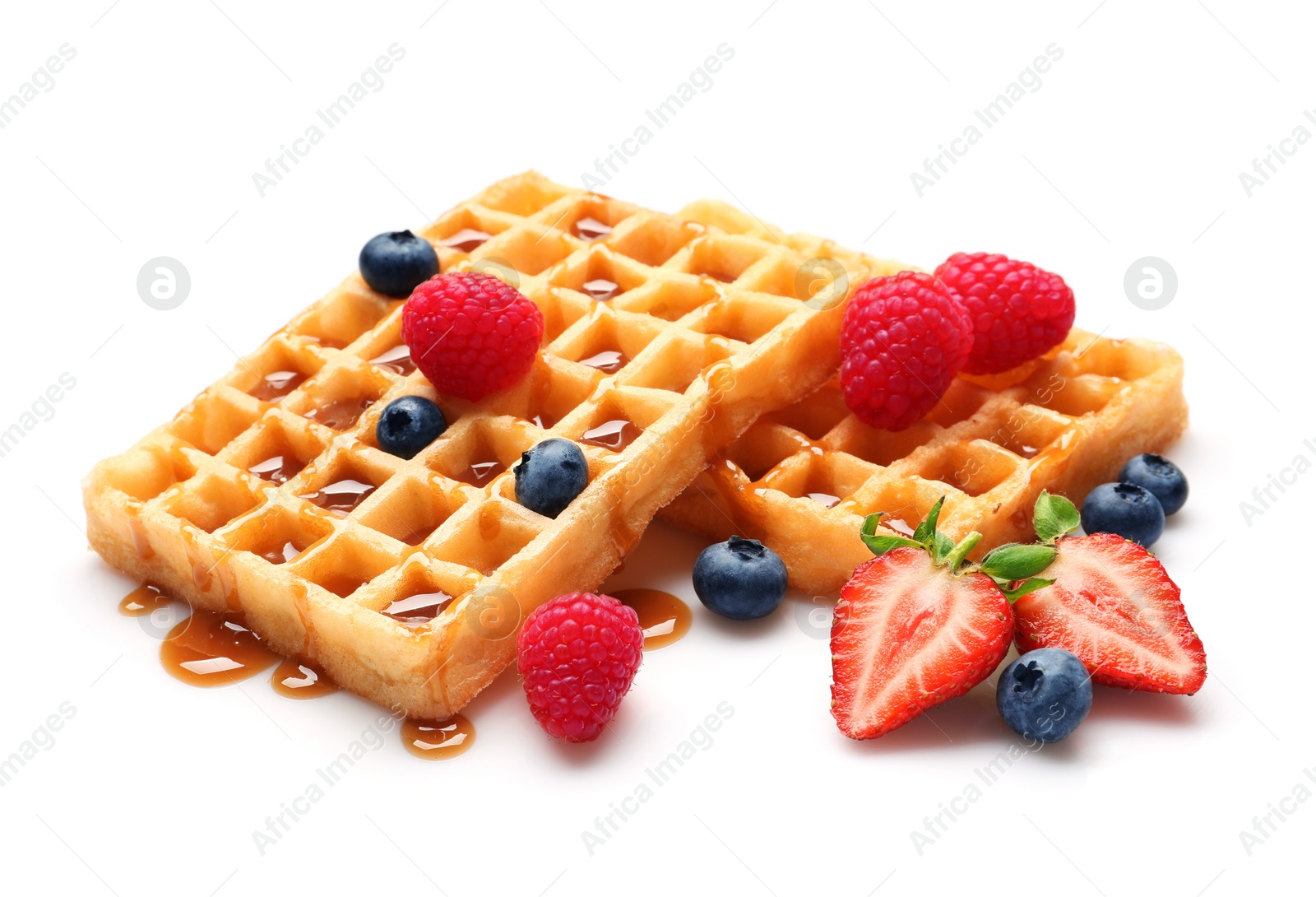 Photo of Yummy waffles with berries and caramel syrup on white background