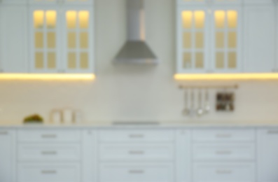 Photo of Blurred view of modern kitchen interior with stylish furniture