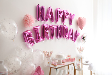 Phrase HAPPY BIRTHDAY made of pink balloon letters in decorated room