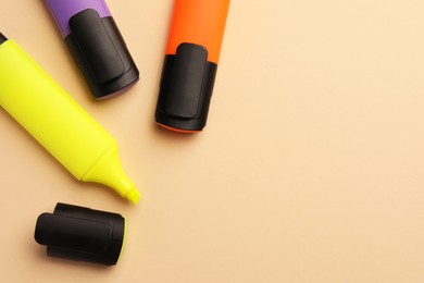 Photo of Bright color markers on beige background, flat lay. Space for text