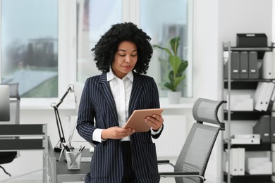 Photo of Young businesswoman using tablet in modern office