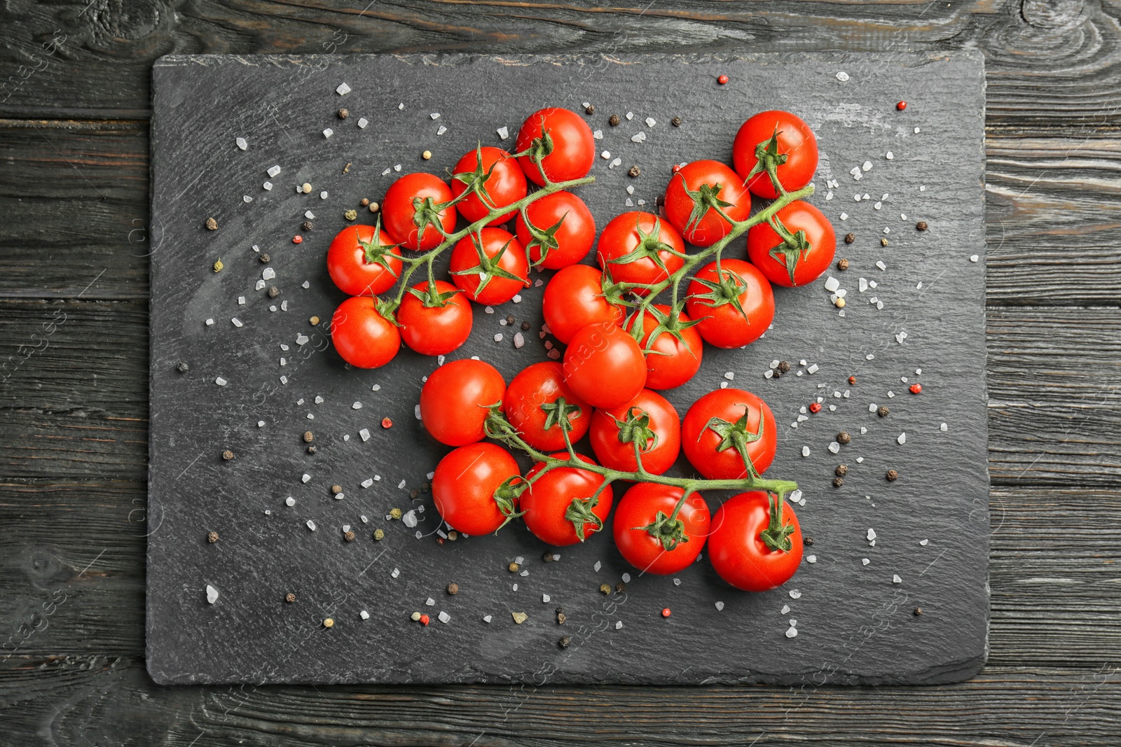 Photo of Slate plate with fresh ripe tomatoes on wooden table, top view