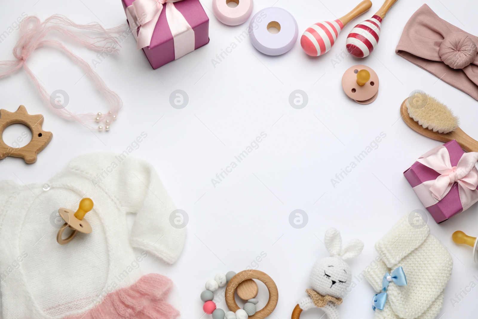 Photo of Frame of baby stuff and gift boxes on white background, top view. Space for text