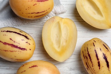 Fresh ripe pepino melons on white wooden table, flat lay