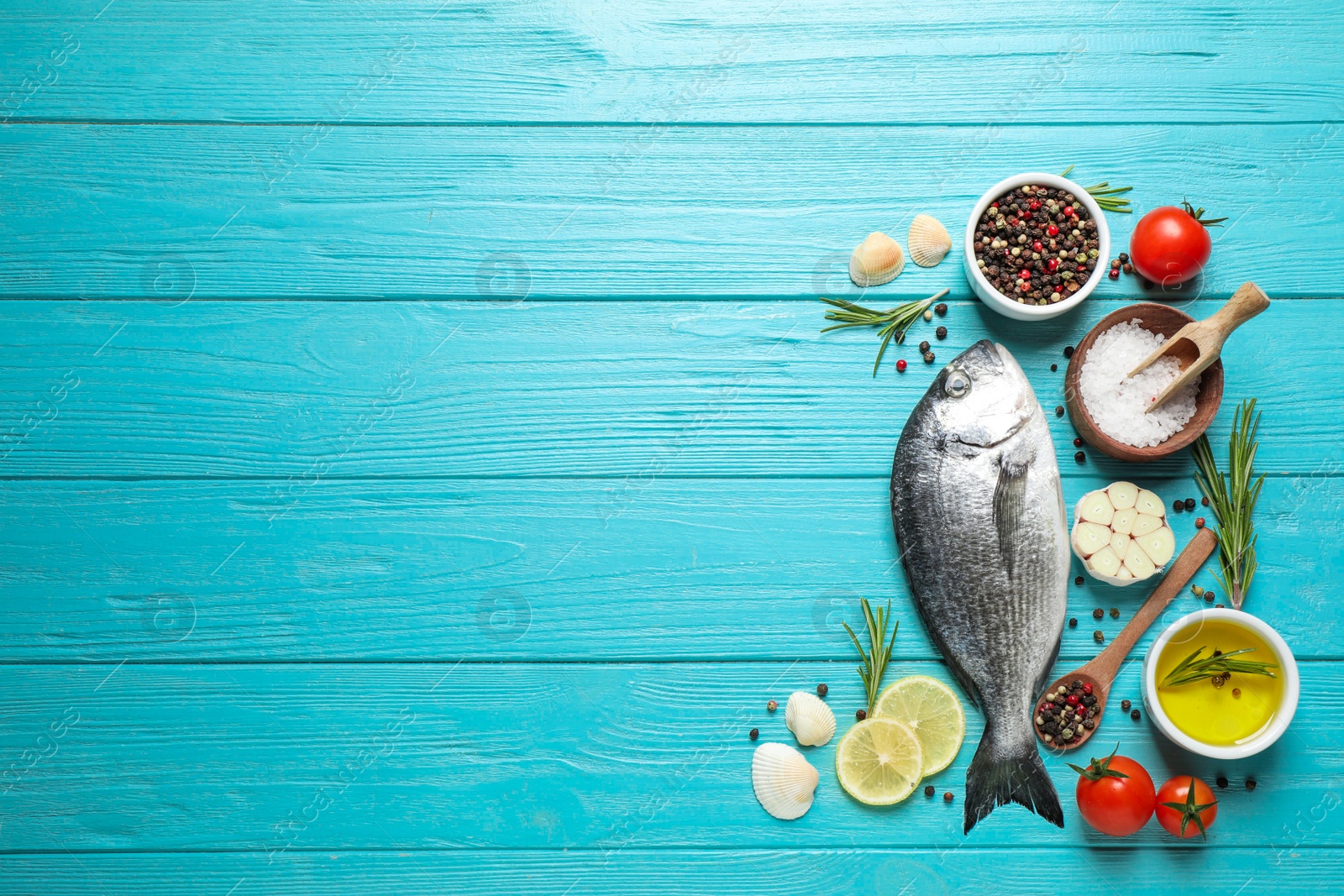 Photo of Flat lay composition with raw dorada fish on light blue wooden table, space for text