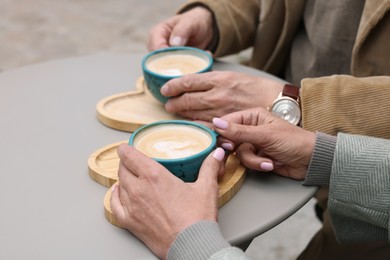 Photo of Affectionate senior couple with coffee at table, closeup