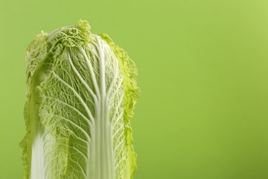 Photo of Fresh ripe Chinese cabbage on light green background, closeup. Space for text