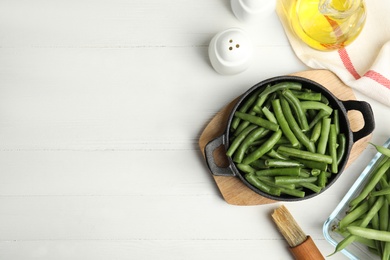 Photo of Flat lay composition with raw green beans on white wooden table. Space for text
