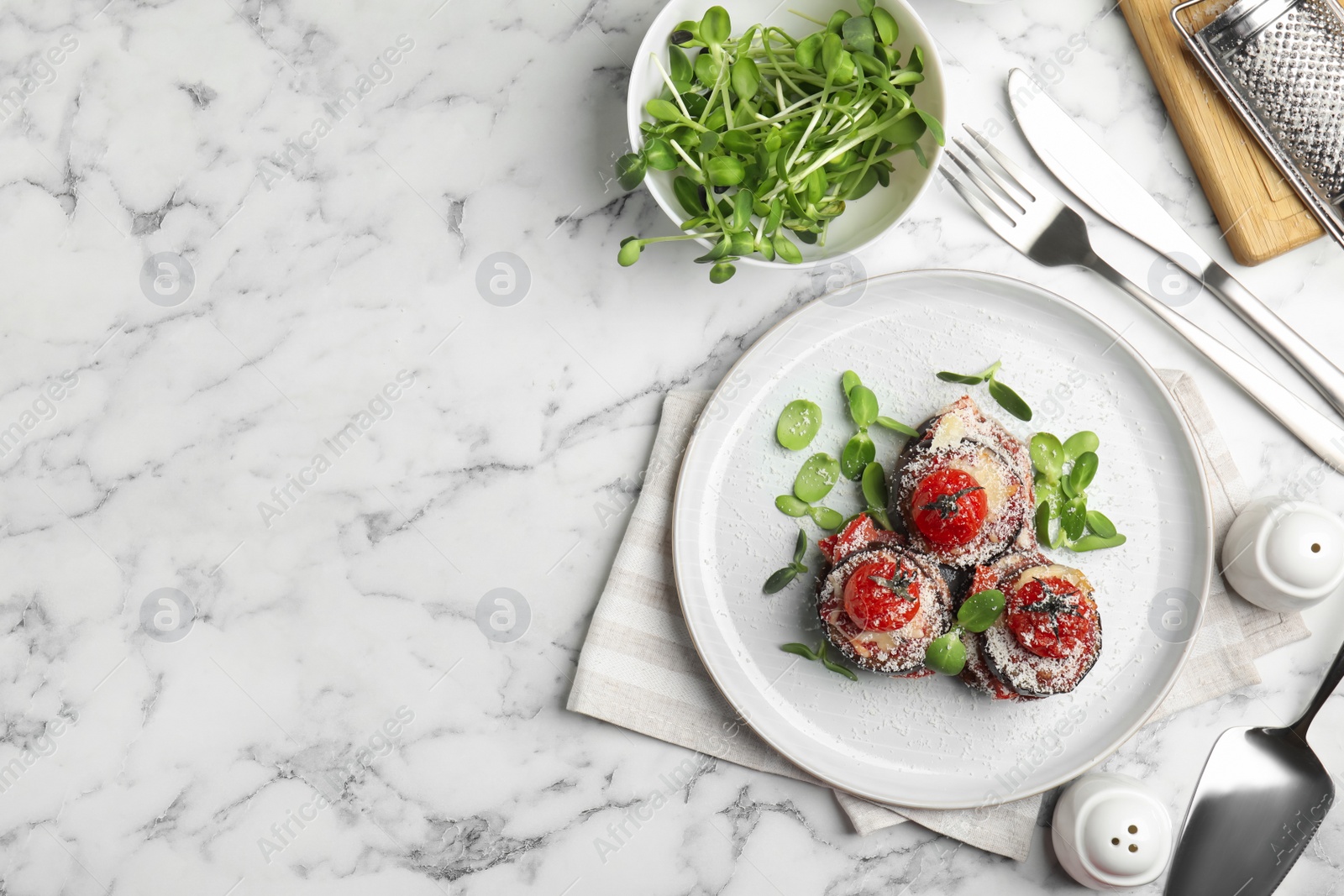 Photo of Baked eggplant with tomatoes, cheese and basil served on white marble table, flat lay. Space for text