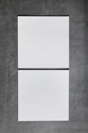 Blank paper sheets on grey textured background, top view. Mockup for design