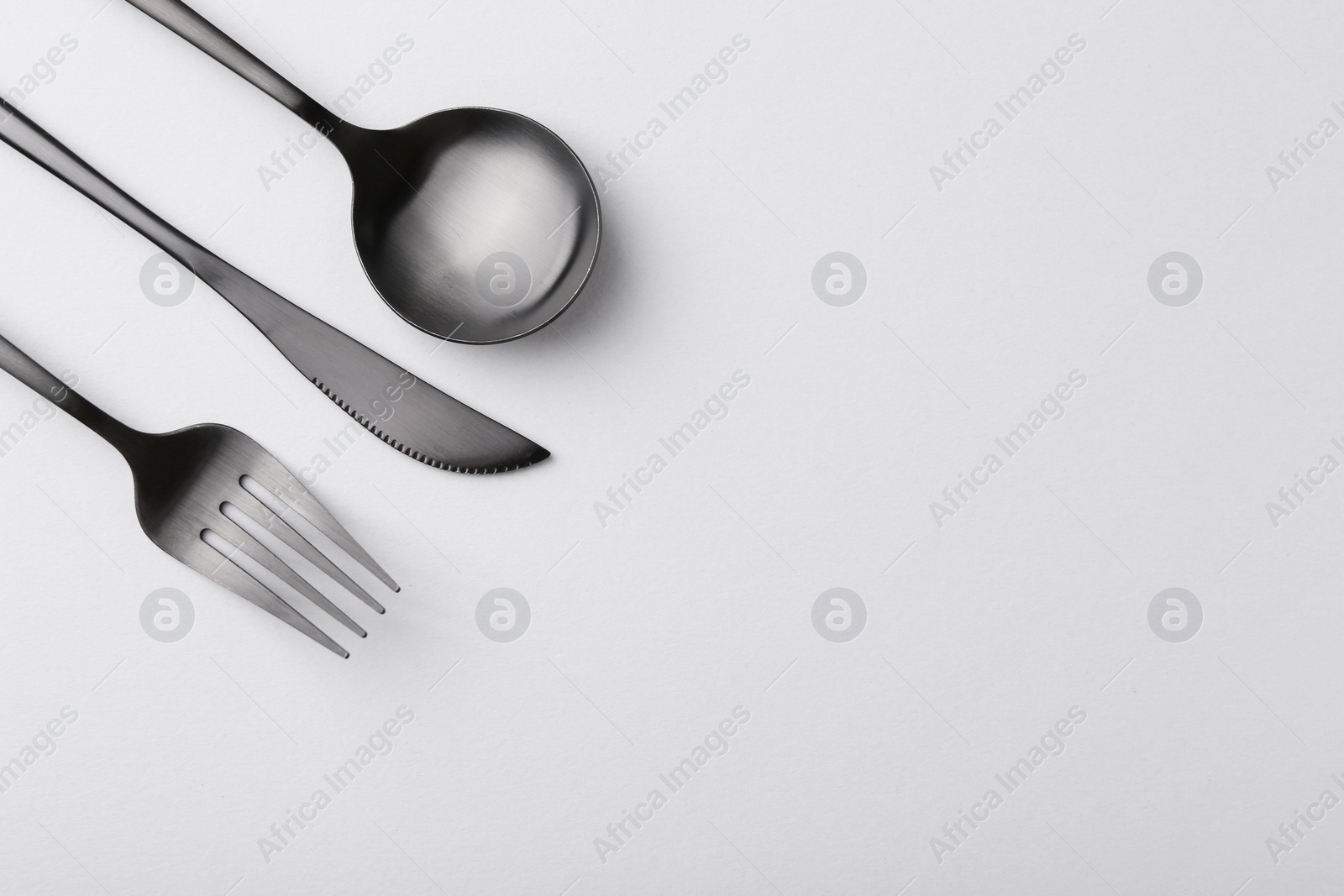 Photo of Stylish cutlery set on grey table, flat lay. Space for text