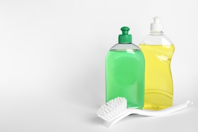 Photo of Different detergents and brush on white background
