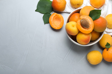 Many fresh ripe apricots on light grey table, flat lay. Space for text