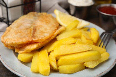 Photo of Delicious fish and chips served on table, closeup