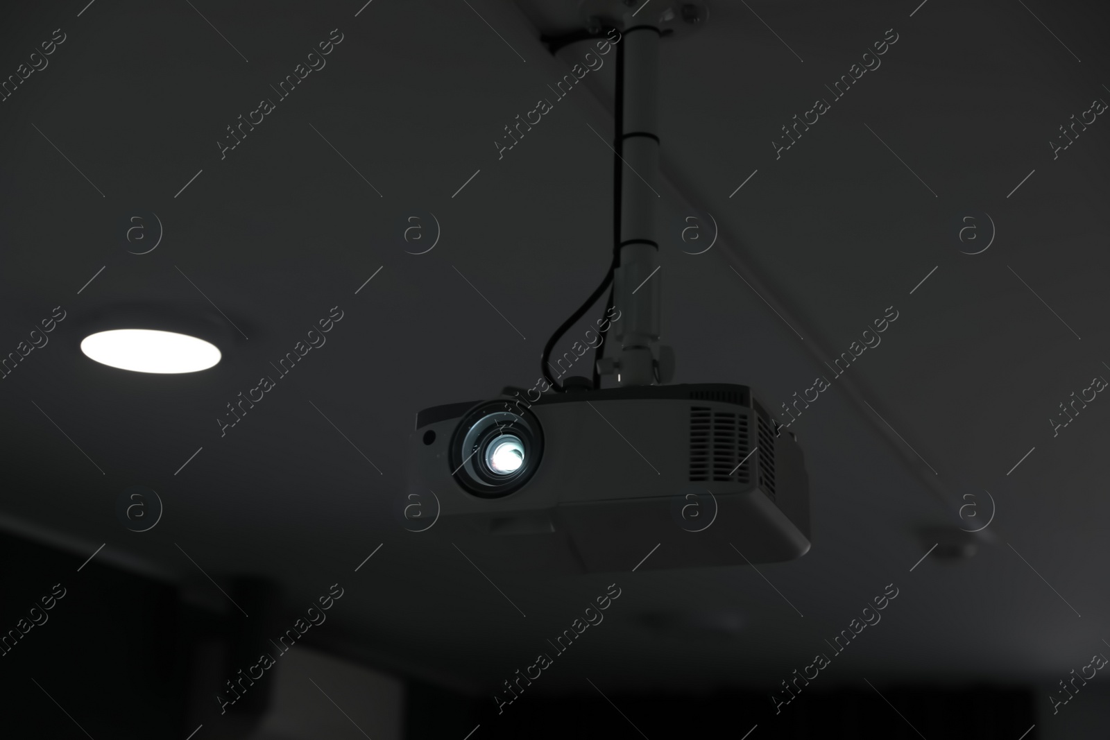 Photo of Modern video projector on ceiling in room