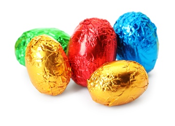 Chocolate eggs wrapped in bright foil on white background