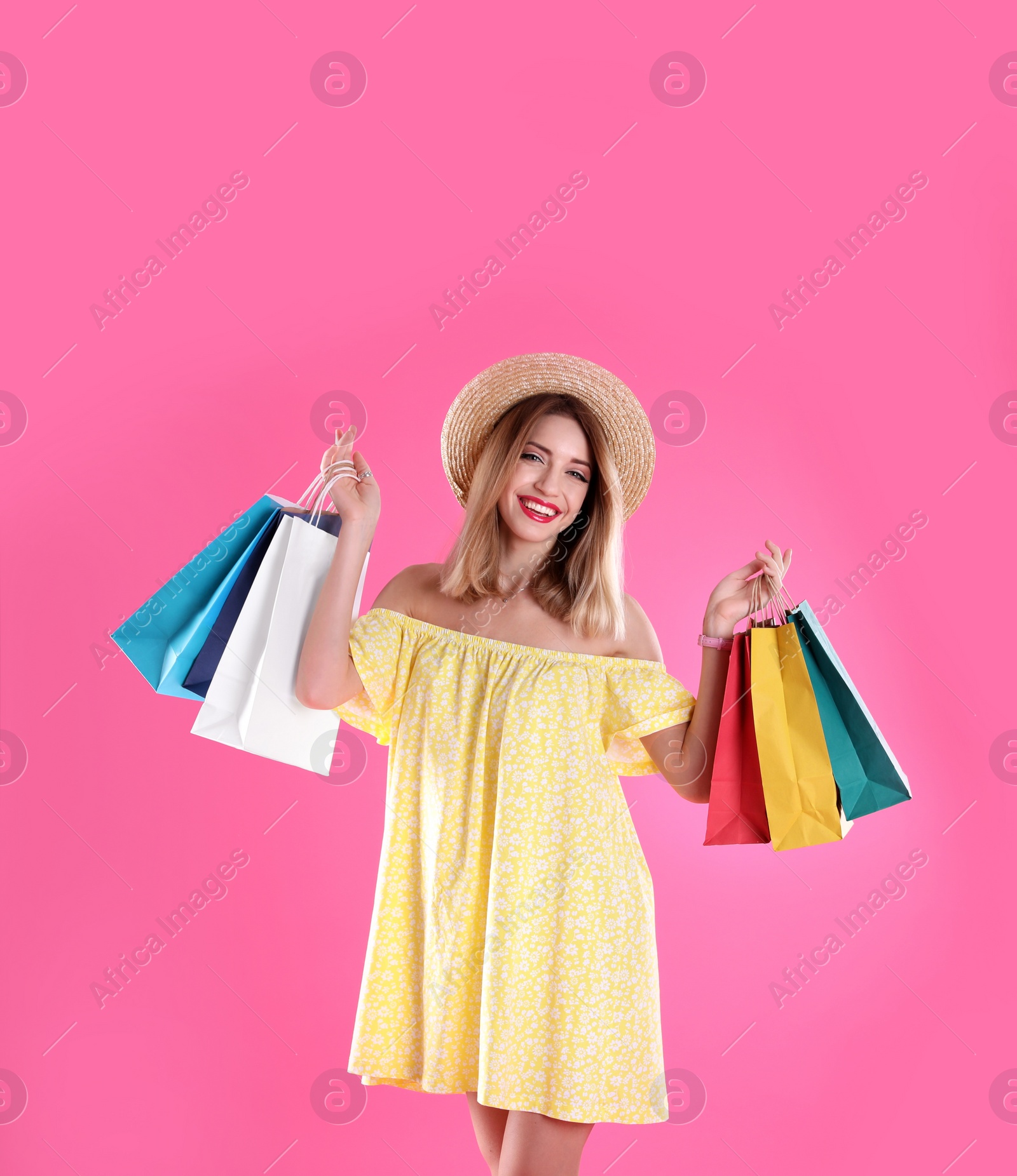 Photo of Beautiful young woman with shopping bags on color background