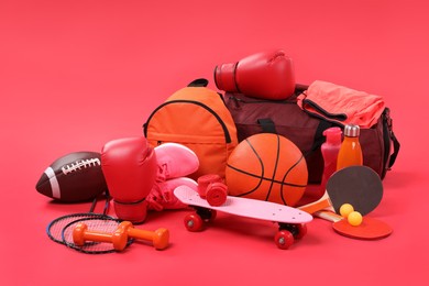 Many different sports equipment on red background