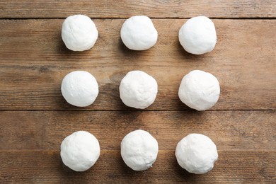 Round snowballs on wooden background, flat lay