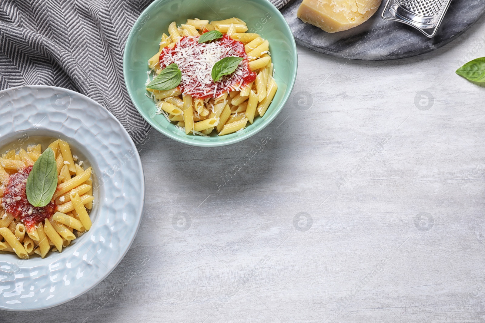 Photo of Delicious pasta with tomato sauce served on white table, flat lay. Space for text