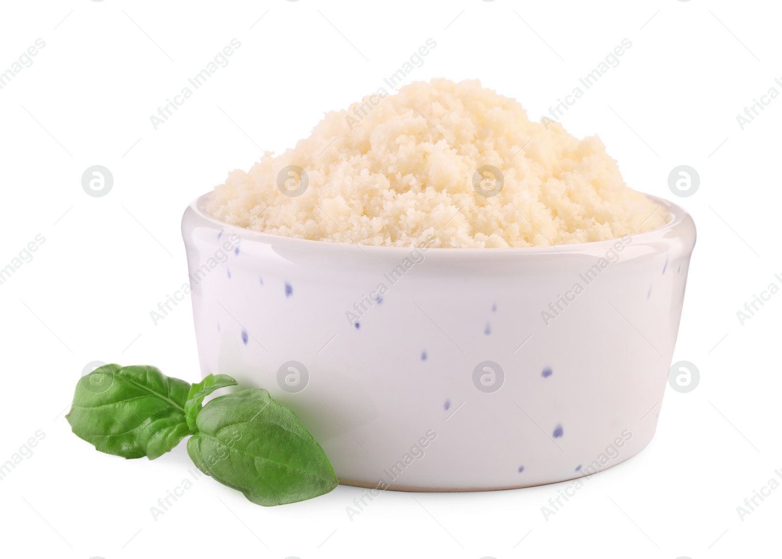 Photo of Delicious grated parmesan cheese in bowl and basil on white background