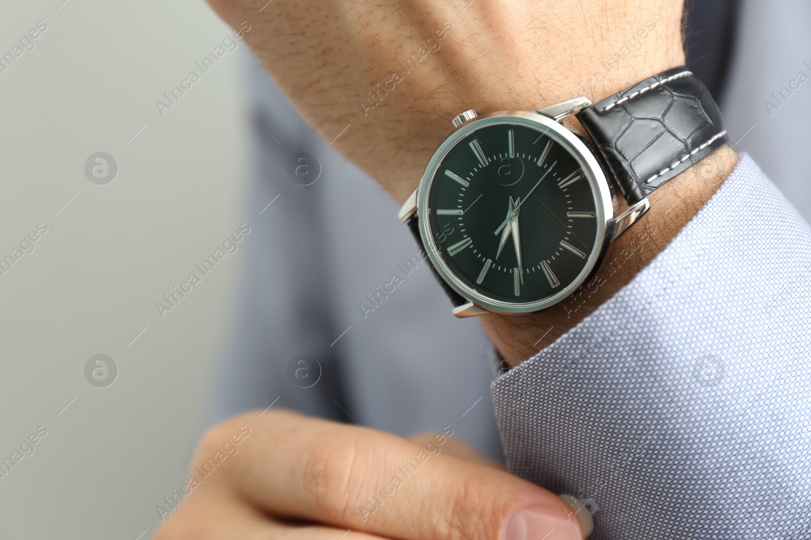 Photo of Man with luxury wrist watch on grey background, closeup. Space for text