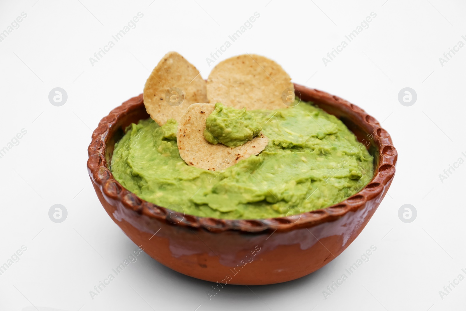 Photo of Delicious guacamole made of avocados with chips on white background, closeup