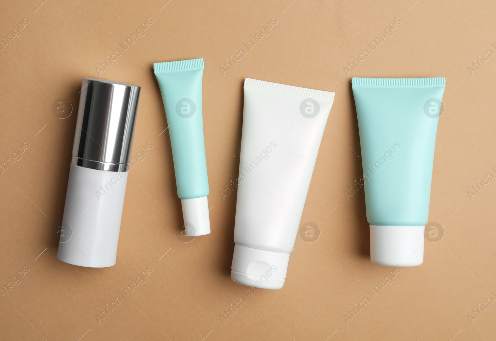 Photo of Set of luxury cosmetic products on light brown background, flat lay