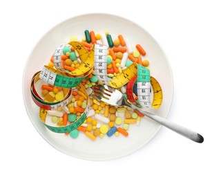 Photo of Plate with weight loss pills, measuring tape and fork on white background, top view