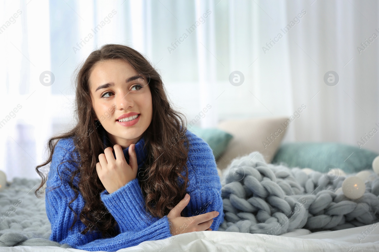 Photo of Portrait of young beautiful woman lying on bed at home