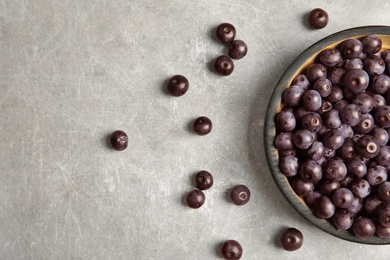 Plate with fresh acai berries on table, top view